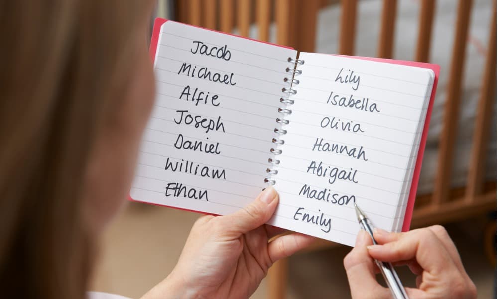 A woman sitting with a notebook of baby names